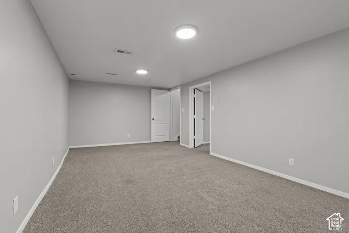 Carpeted room with light gray walls, white trim, and recessed lighting