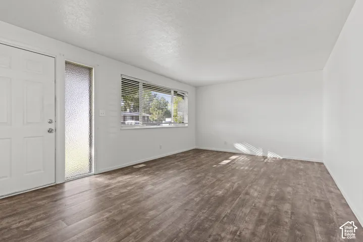 Neutral wall colors, wood-finish flooring, and multiple windows with blinds