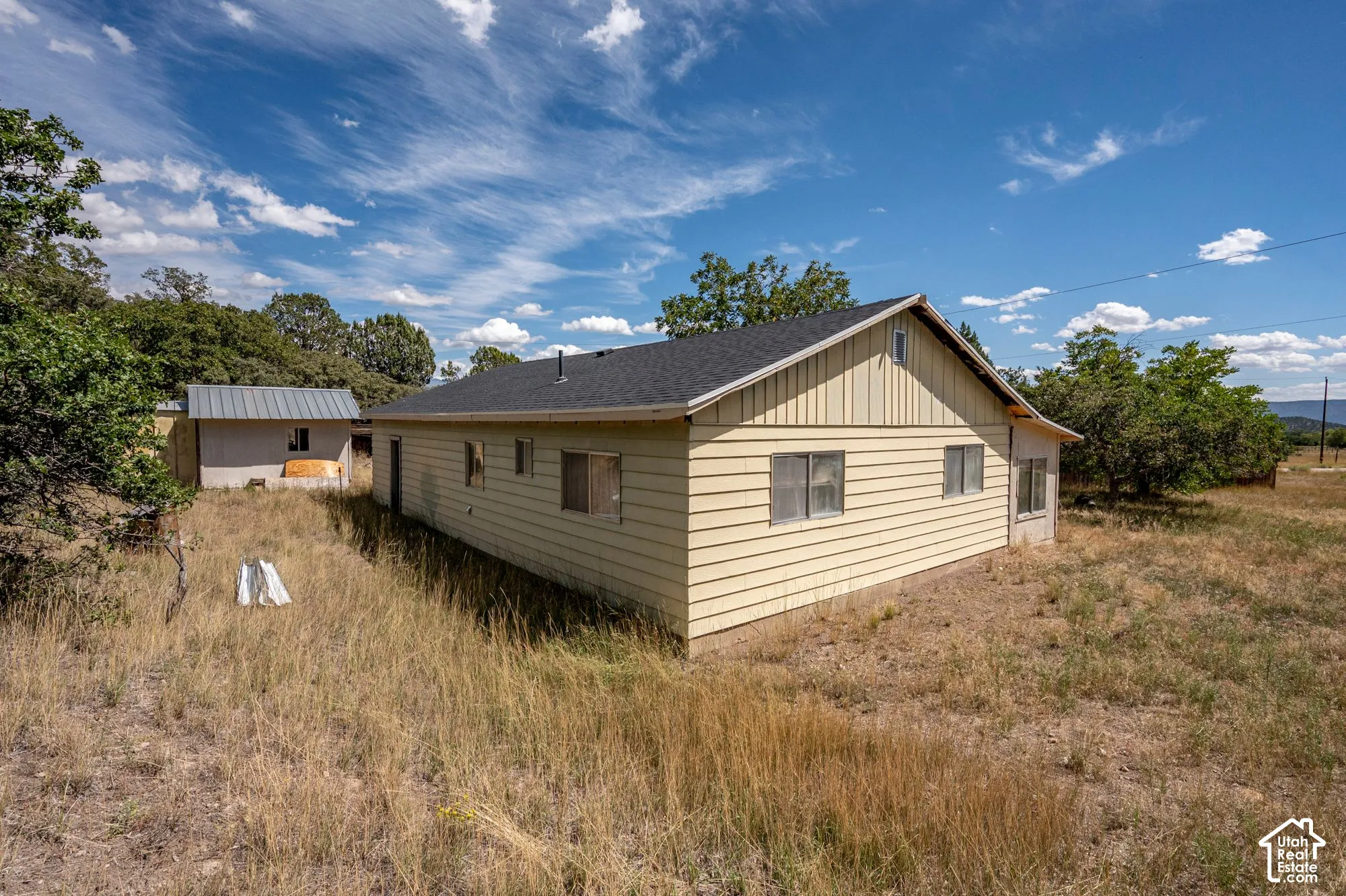 Single-story residence with horizontal siding, a dark shingle roof, and multiple windows