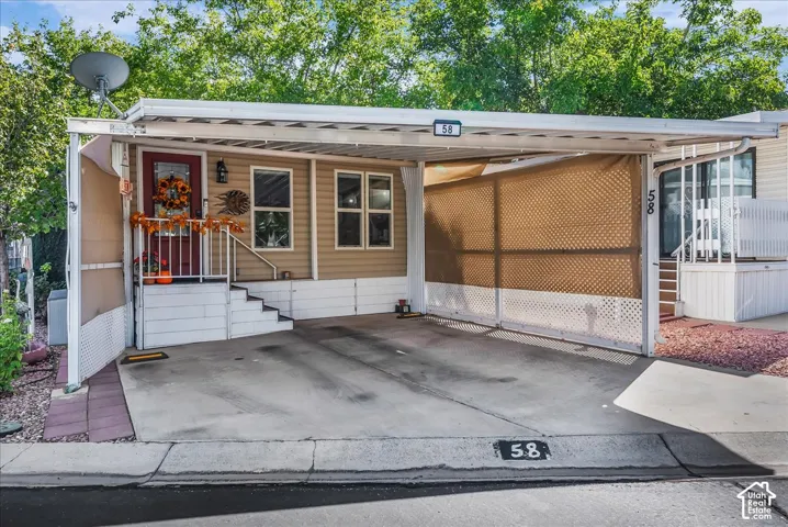 Carport with concrete pad, covered entry with steps and handrail, and exterior siding