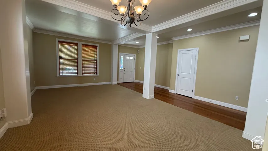 Carpeted and wood-finish flooring with crown molding and recessed lighting