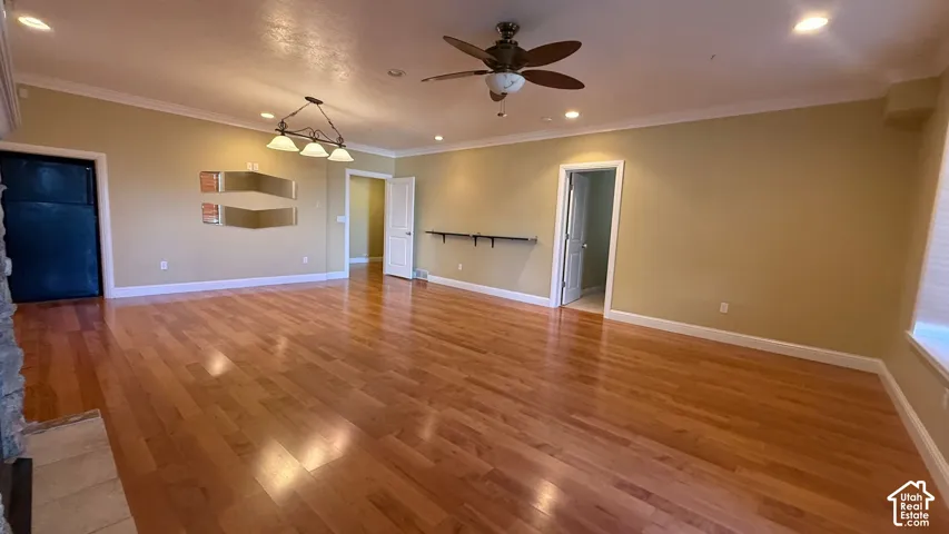 Hardwood flooring with recessed lighting, crown molding, and a ceiling fan