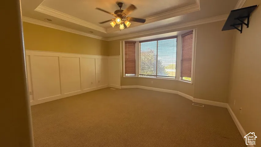 Bay window with horizontal blinds, tray ceiling, recessed lighting, and a ceiling fan