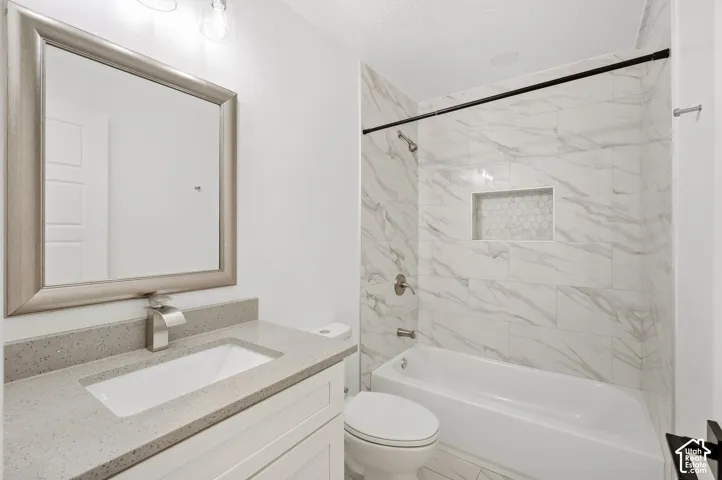 Bathroom featuring a single vanity with an undermount sink, a gray countertop, and white cabinetry