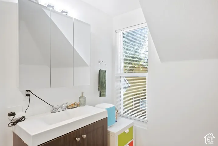 Vanity with an integrated sink, polished chrome faucet, and wood-finish cabinetry
