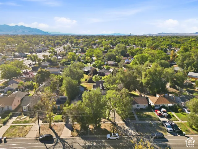 Expansive neighborhood setting with mature trees and mountain backdrop