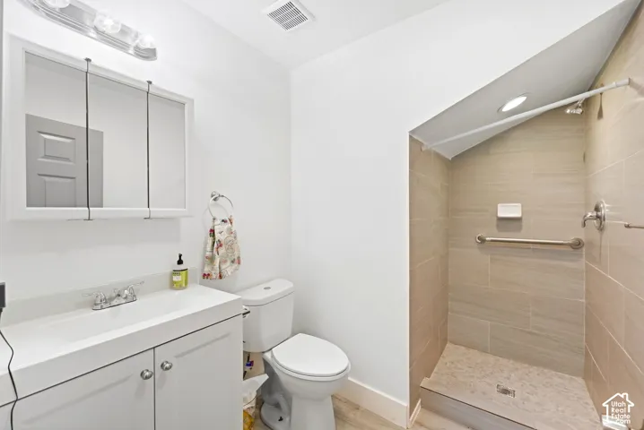 Recessed shower with light tile surround, built-in grab bar, and a single-handle fixture
