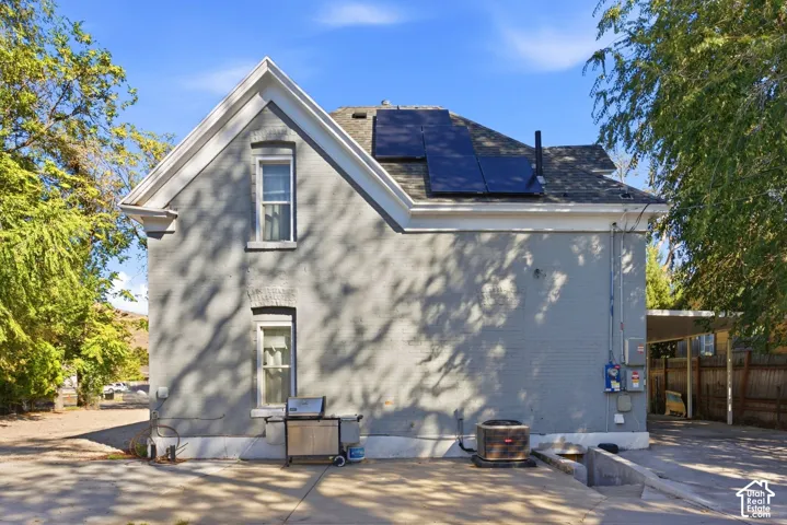 Brick exterior with white trim, a gabled roof, and solar panels. Back of main house.