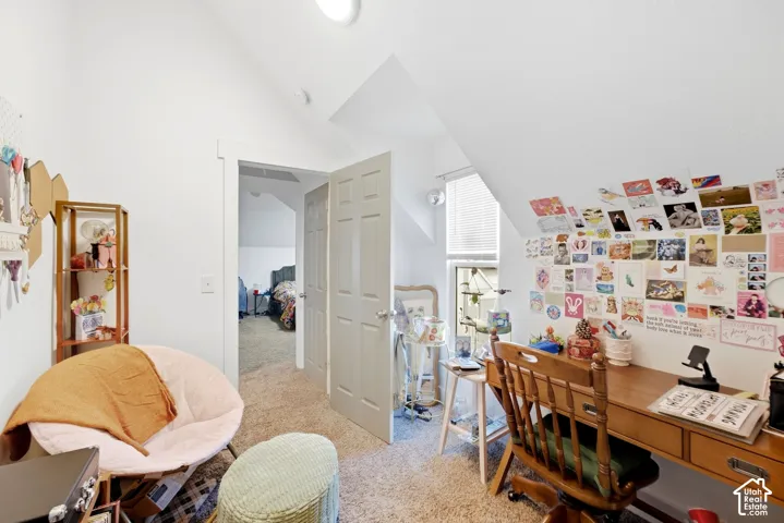 Attic space with vaulted ceilings, neutral wall paint, and carpeted flooring