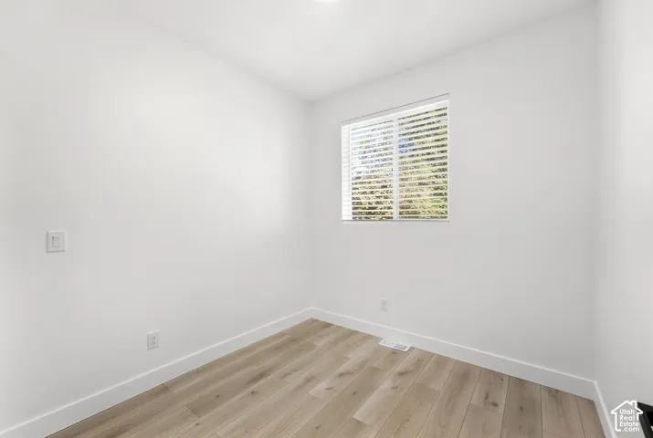 Wood-finish flooring with white baseboards and light-toned walls