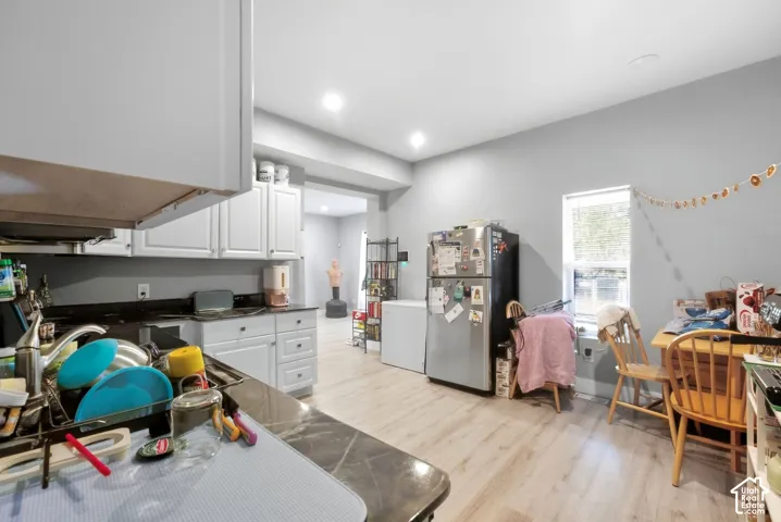 Kitchen featuring white cabinetry, dark countertops, wood-finish flooring, and recessed lighting