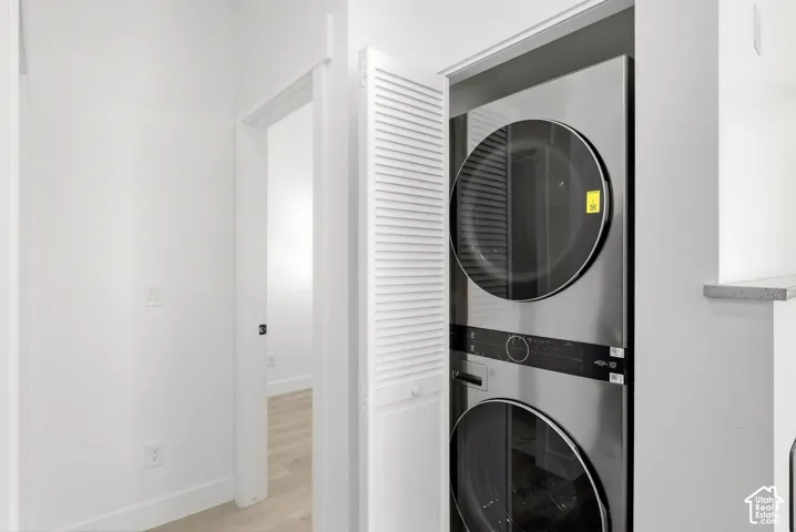 Integrated stacked laundry appliances within a louvered bifold door enclosure