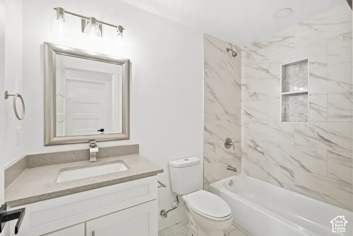White vanity with a neutral countertop, undermount sink, and brushed nickel faucet