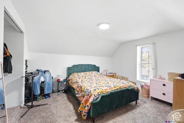 Sloped ceilings, wall-to-wall carpeting, and a window with white trim