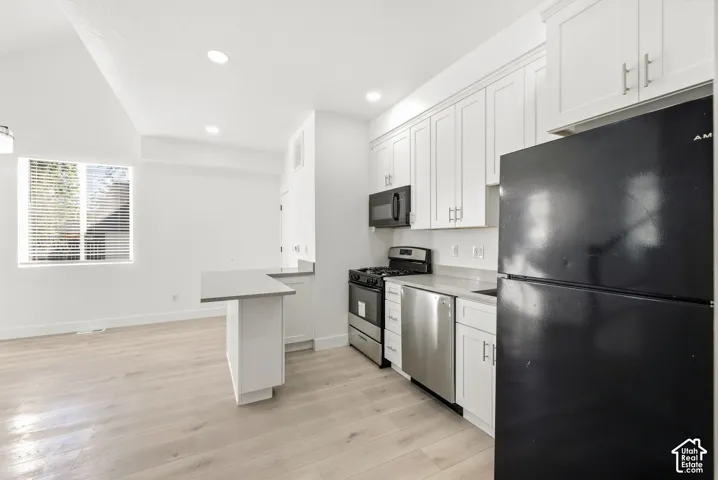 Kitchen featuring white cabinetry, gray countertops, and stainless steel appliances