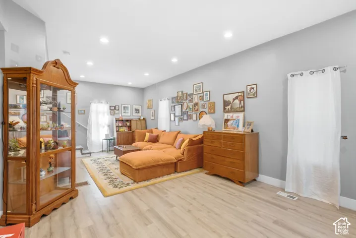 Recessed ceiling lighting, light gray wall color, light wood-finish flooring, and white trim
