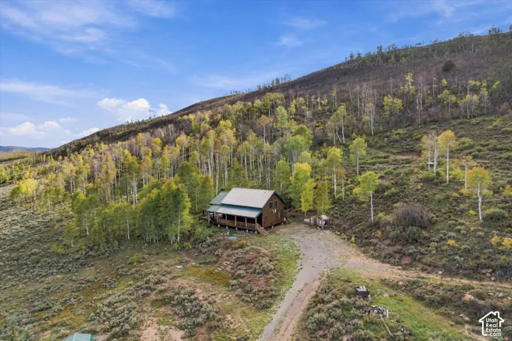 Wood-sided cabin featuring a covered wrap-around porch and a metal roof