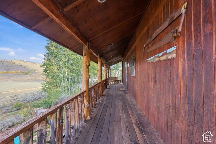 Expansive wood-plank deck with natural wood railing and log columns