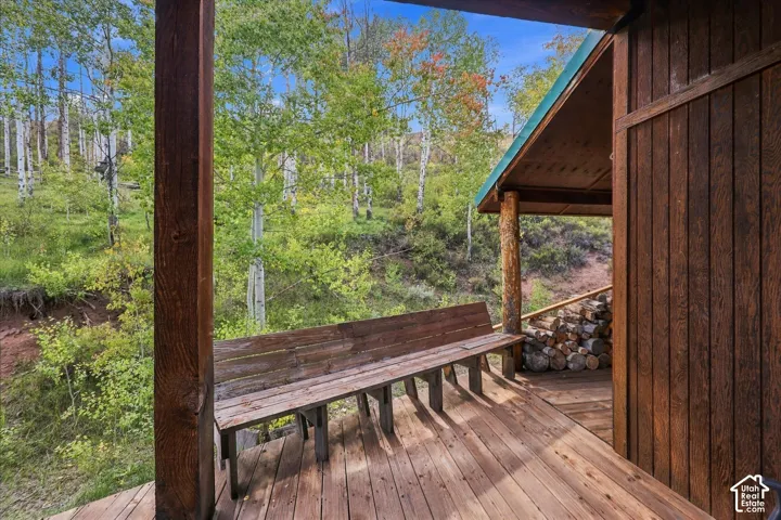 Wood deck with a built-in bench, exposed wood columns, and wood-paneled siding