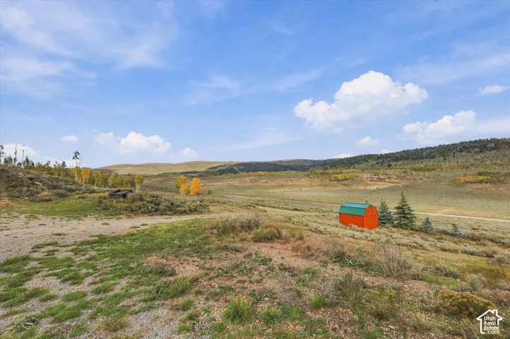 Expansive landscape featuring distant hills and scattered trees
