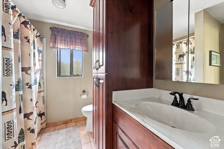 Bathroom featuring a wood-finish vanity with an integrated sink and a bronze-finish faucet