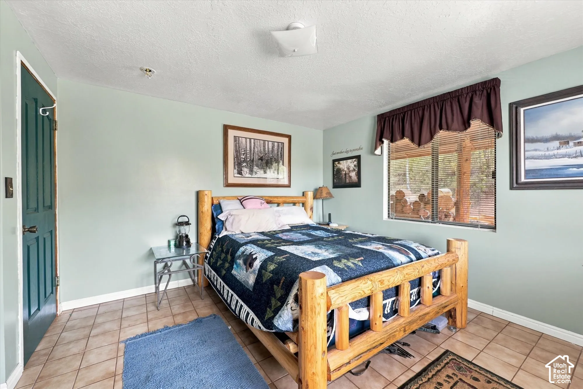 Room featuring light green painted walls, ceramic tile flooring, and a single window with blinds