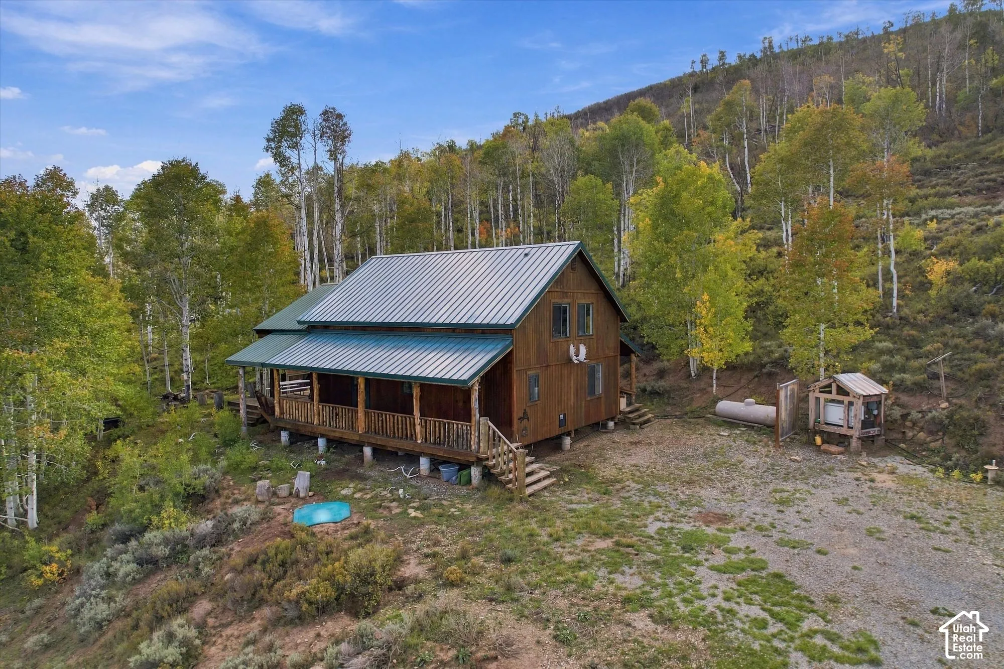 Log cabin-style residence featuring a metal roof and an expansive covered porch