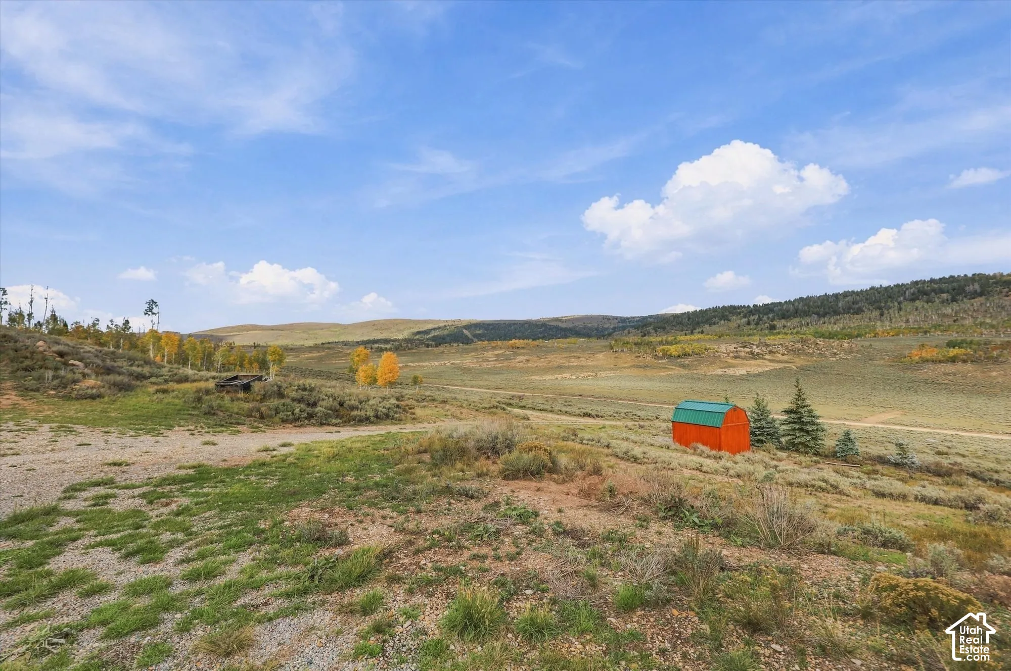 Expansive landscape featuring distant hills and scattered trees