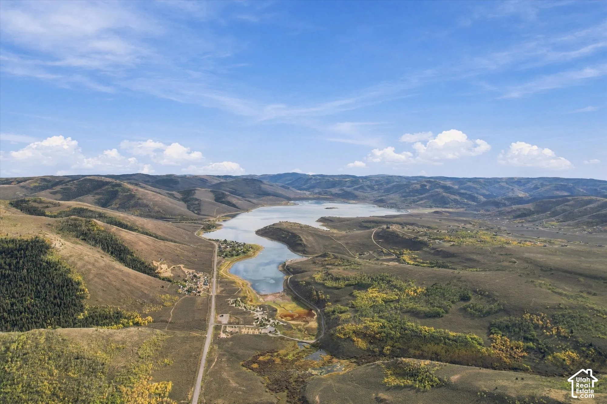 Expansive landscape featuring rolling hills and a large body of water