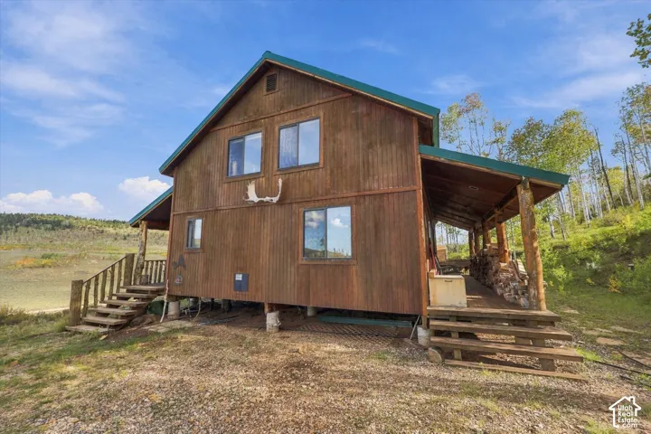 Wood-clad exterior with a green roof, supported by visible pilings
