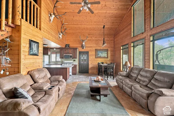 Vaulted wood-finish ceilings, wood-finish wall paneling, multi-pane windows, wood-finish flooring, and an open loft area