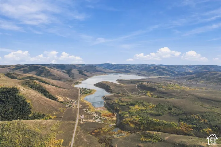 Expansive landscape featuring rolling hills and a large body of water