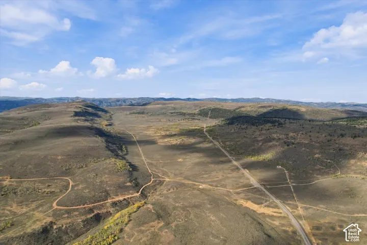 Expansive undeveloped terrain featuring established roadways and distant mountain ranges