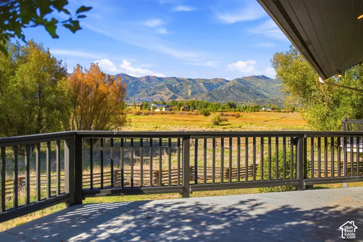 Expansive outdoor deck with dark railing and mountain backdrop