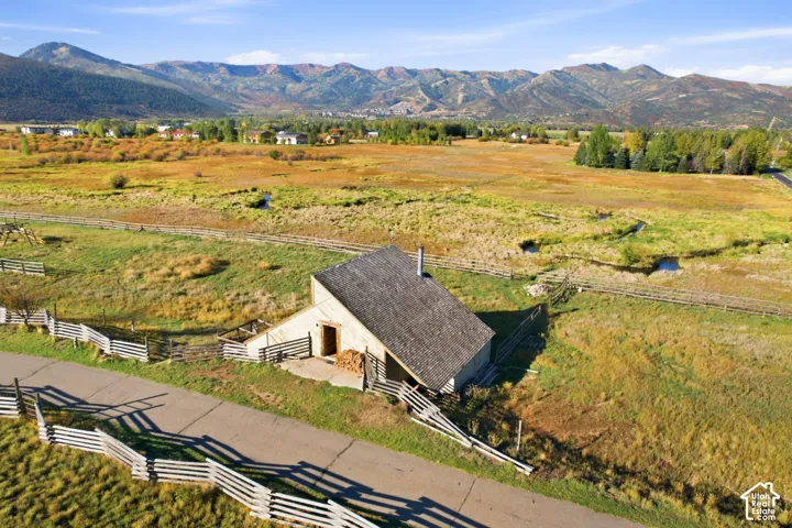 Barn-style structure with a prominent gabled roof and split-rail fencing