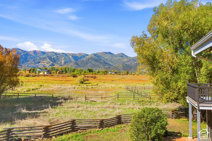 Expansive natural landscape featuring a split-rail fence and distant mountains