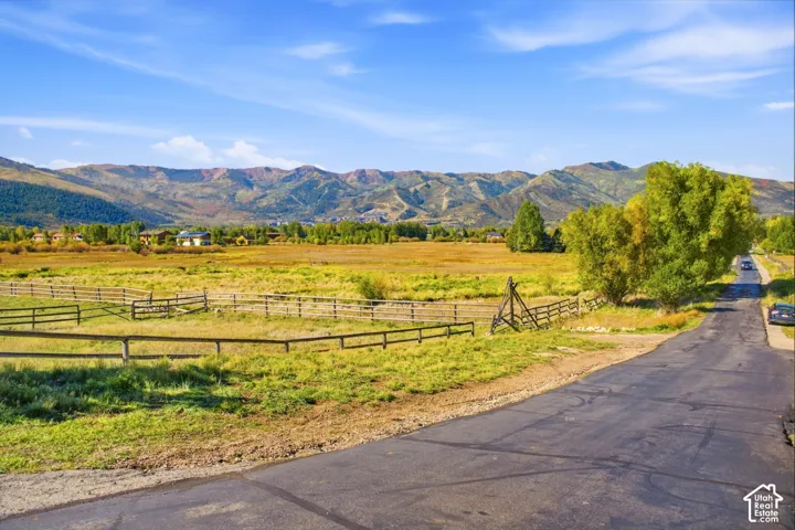 Expansive open fields with natural landscaping, bordered by a multi-rail fence
