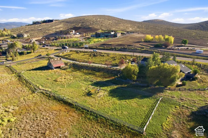 Expansive property featuring a rustic barn structure, surrounding natural landscape, and distant residential structures