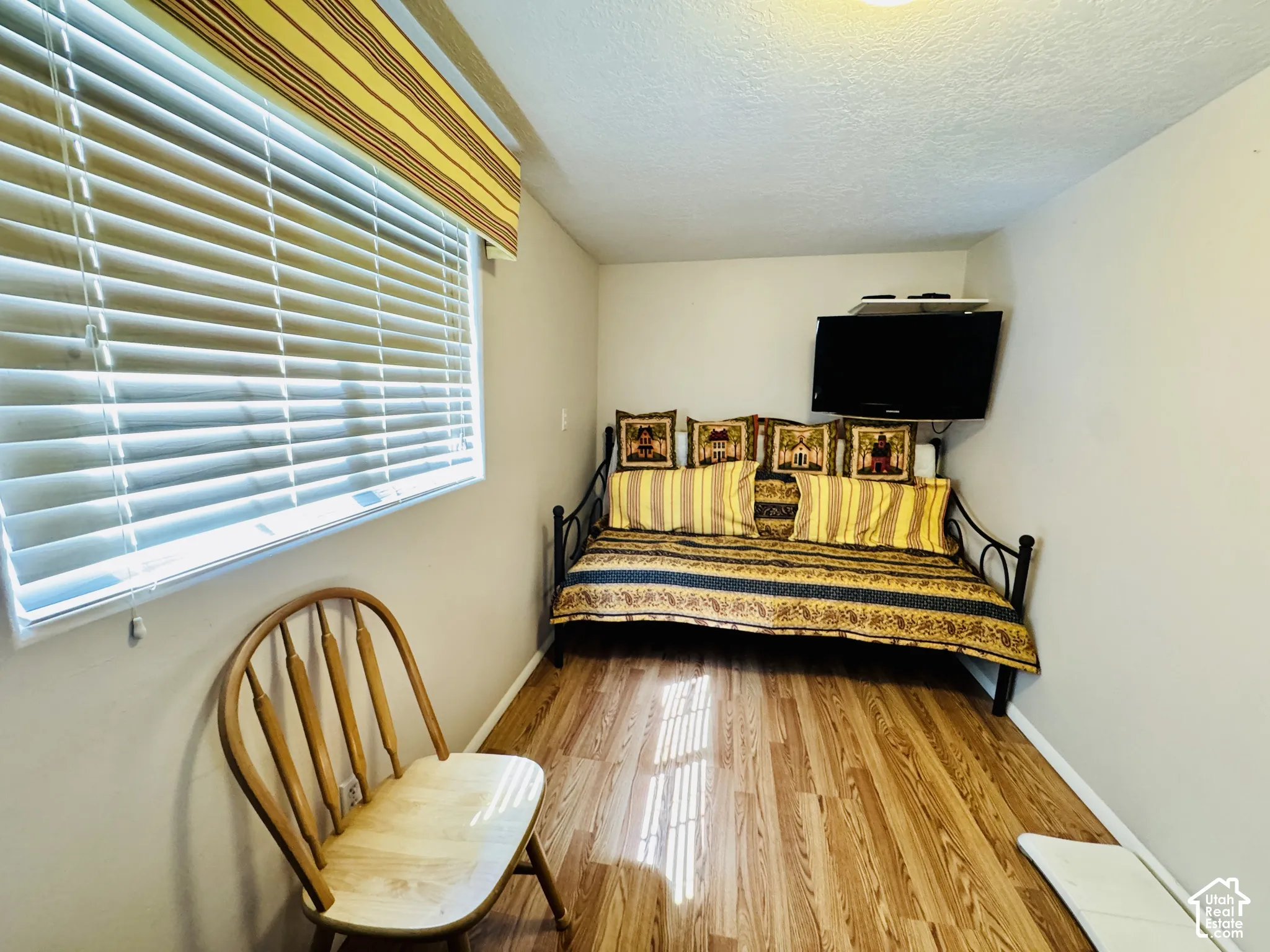 Wood-finish flooring, window with blinds, recessed ceiling lighting, and light-toned wall paint