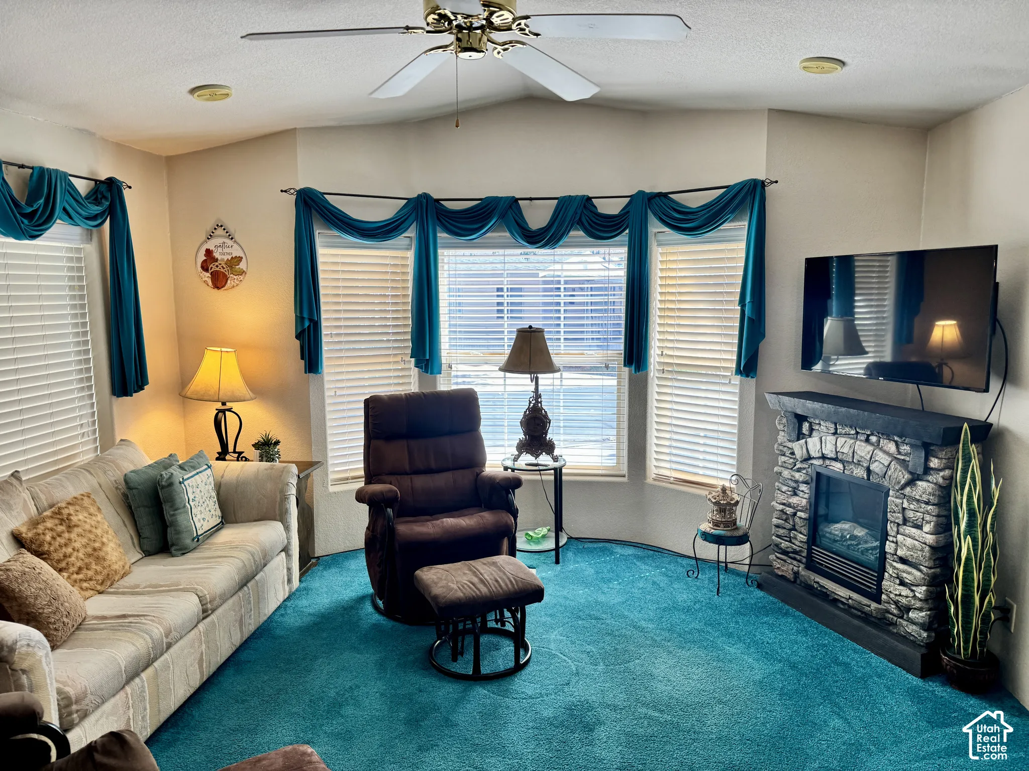 Bay window with horizontal blinds, ceiling fan, and recessed lighting