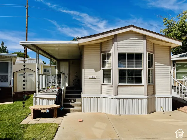 Exterior features a covered front porch, bay window, horizontal siding, and a paved driveway