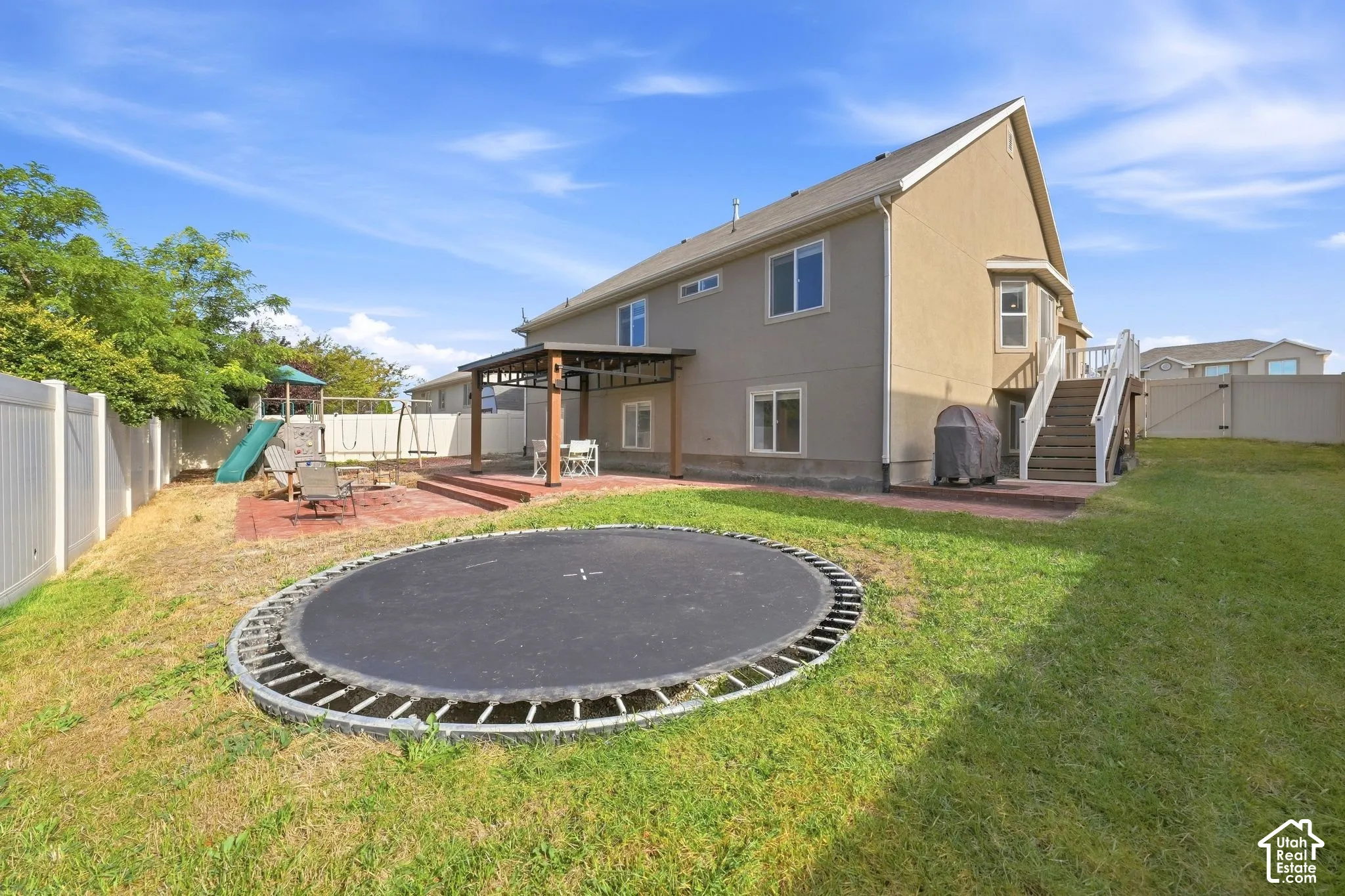 Expansive backyard featuring a patio, covered pergola, and privacy fencing