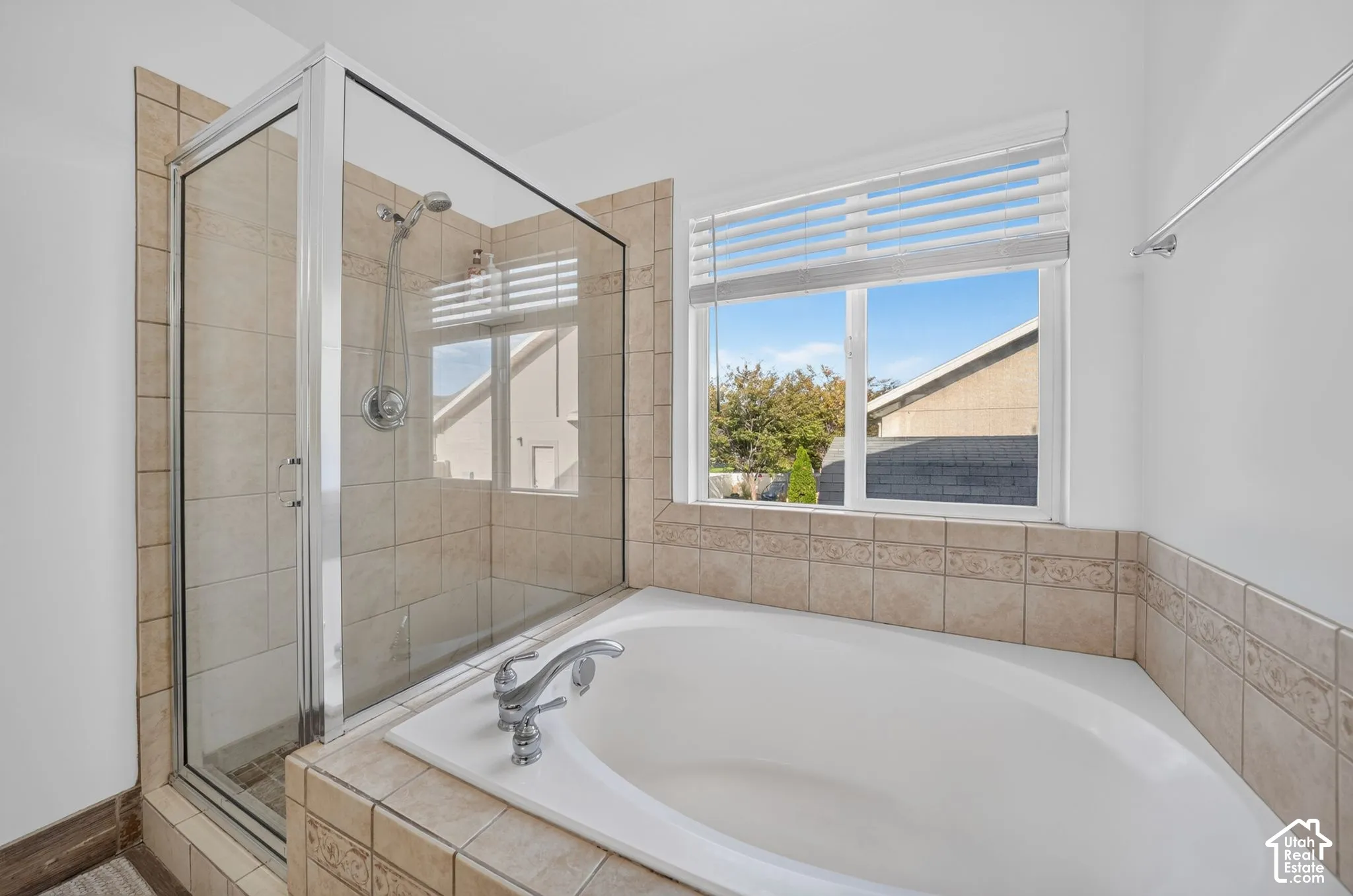 Walk-in shower with clear glass enclosure and tile surround