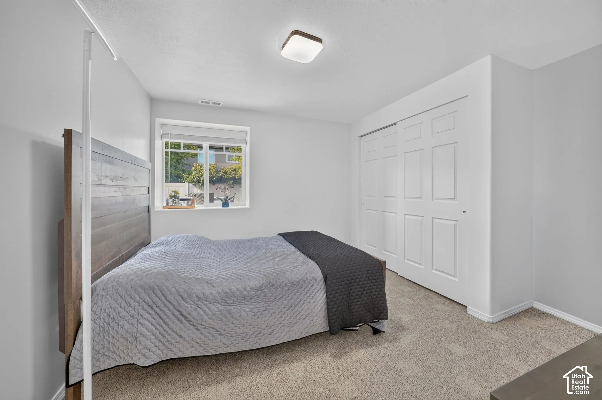 Recessed window with white trim, wall-to-wall carpeting, and sliding panel closet doors
