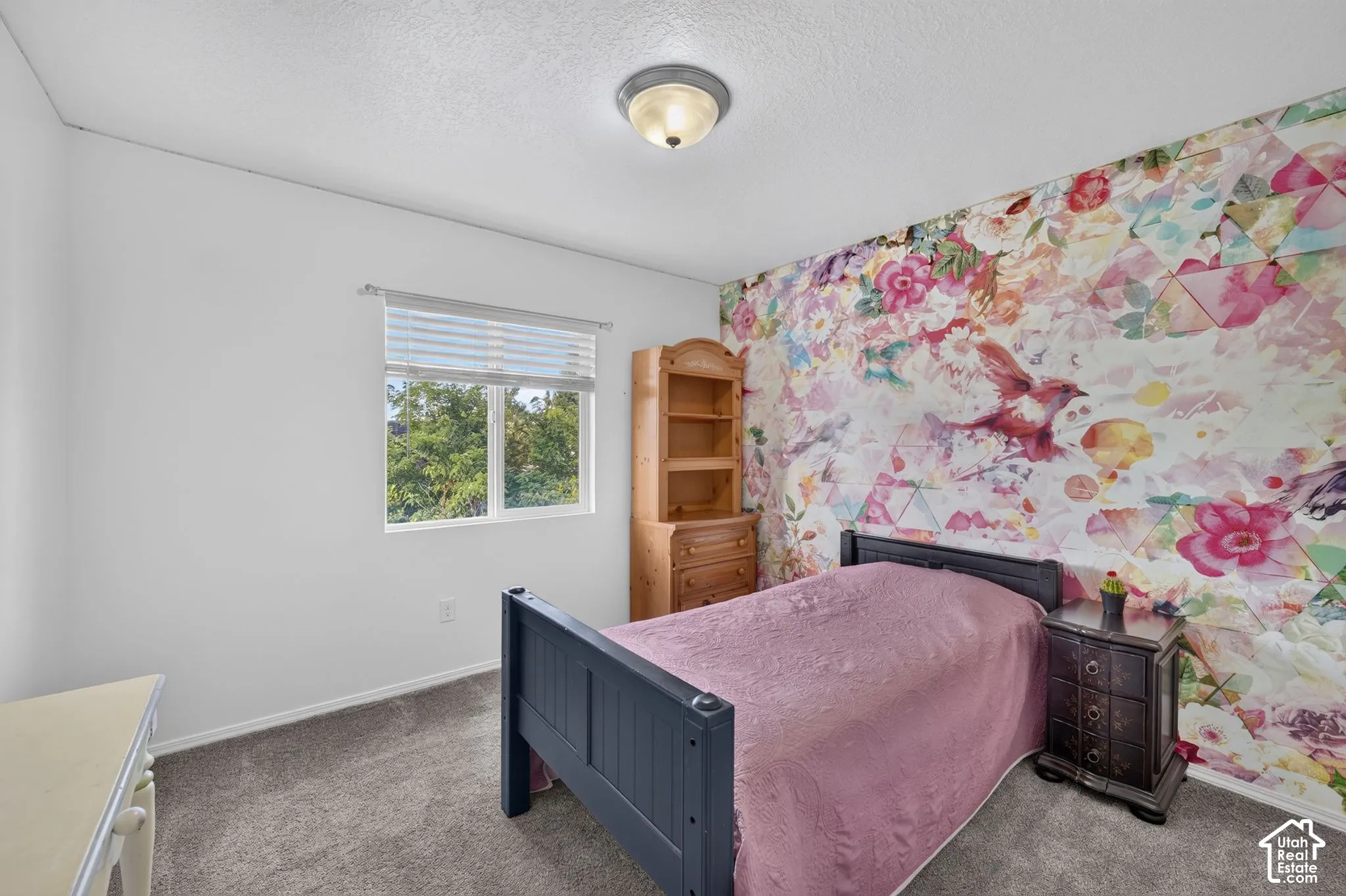 Window with blinds, wall-to-wall carpeting, and a decorative accent wall