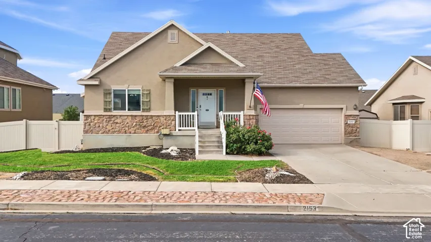 Stucco exterior with stone-clad accents and a covered front porch