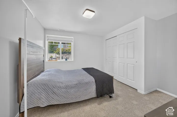 Recessed window with white trim, wall-to-wall carpeting, and sliding panel closet doors