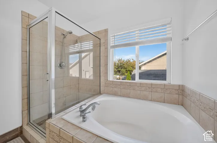 Walk-in shower with clear glass enclosure and tile surround