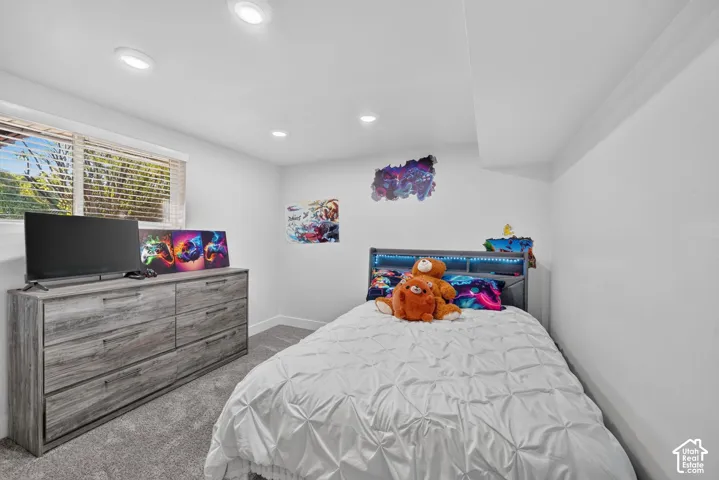Recessed lighting illuminates neutral walls and gray carpeting