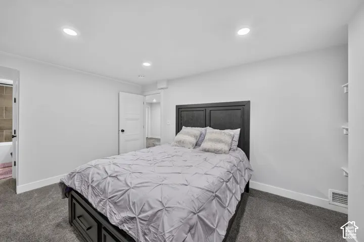 Recessed lighting illuminates the space, featuring gray carpeting and white baseboards